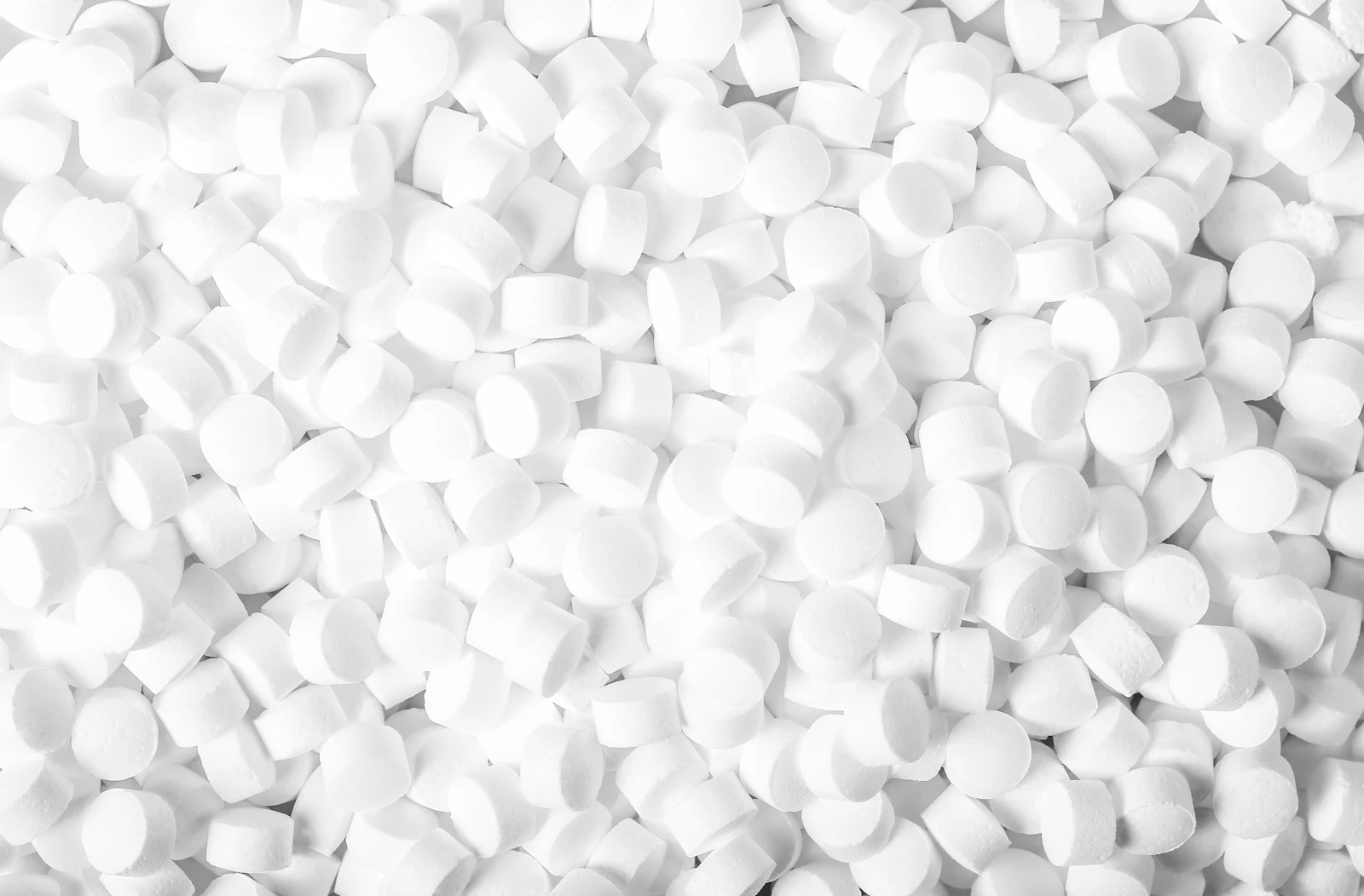 A pile of white loose-fill packing peanuts, representing void fill for shipping boxes