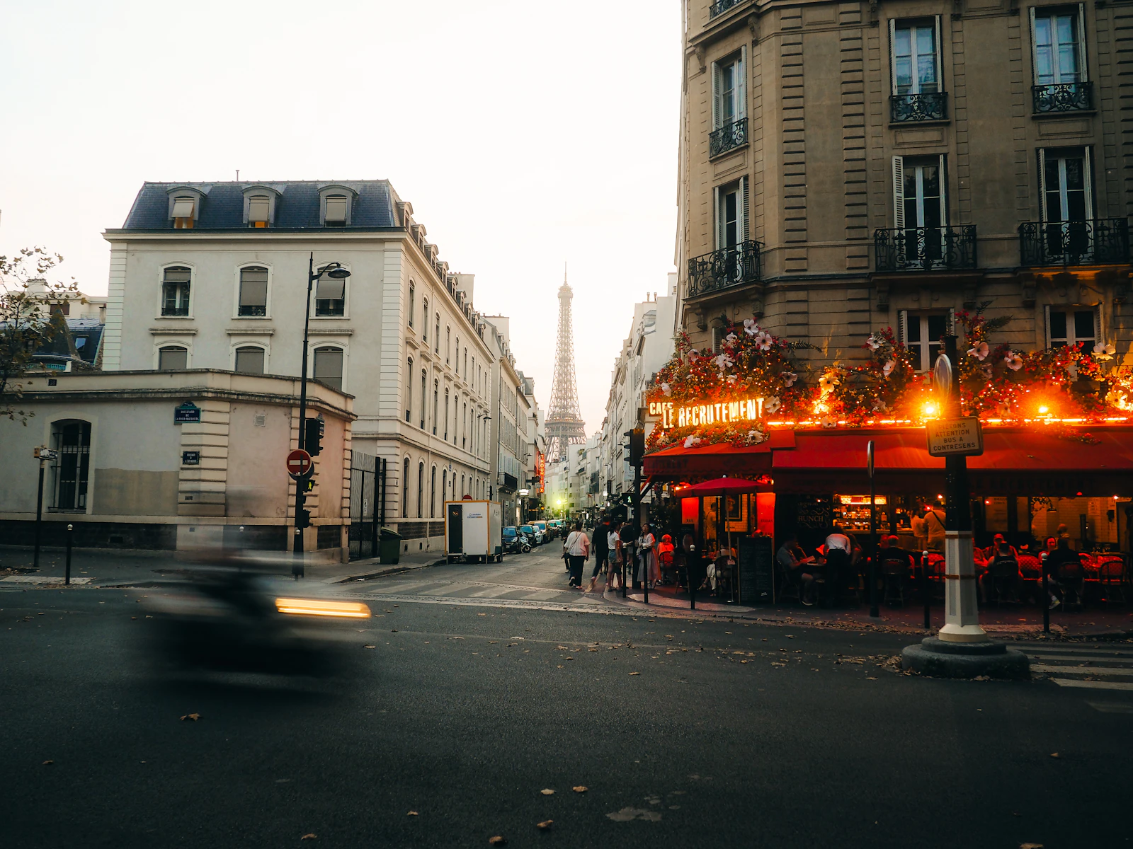 A Parisian street corner at dusk with a cafe and the Eiffel Tower, representing packaging sold on the French market
