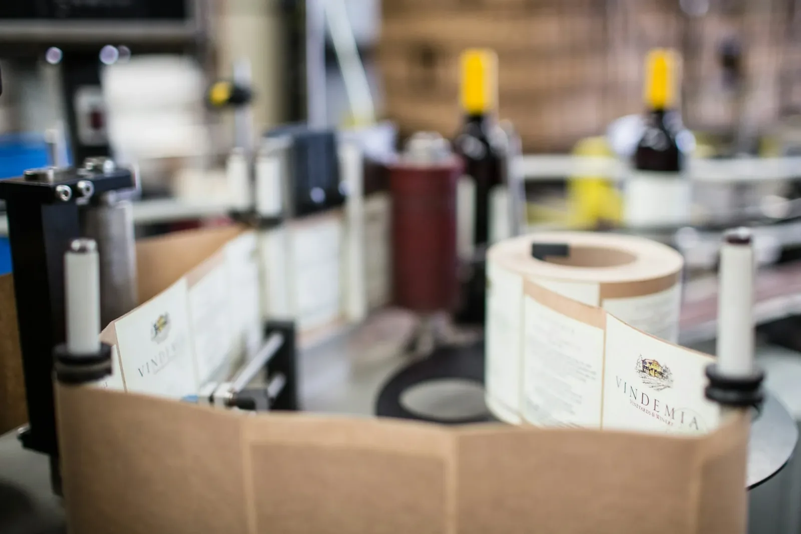 Automated labelling machine applying printed labels to bottles on a production line
