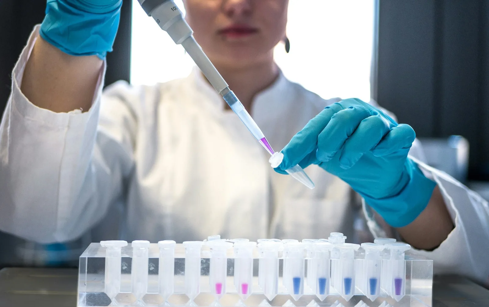 A scientist using a pipette and test tubes in a laboratory