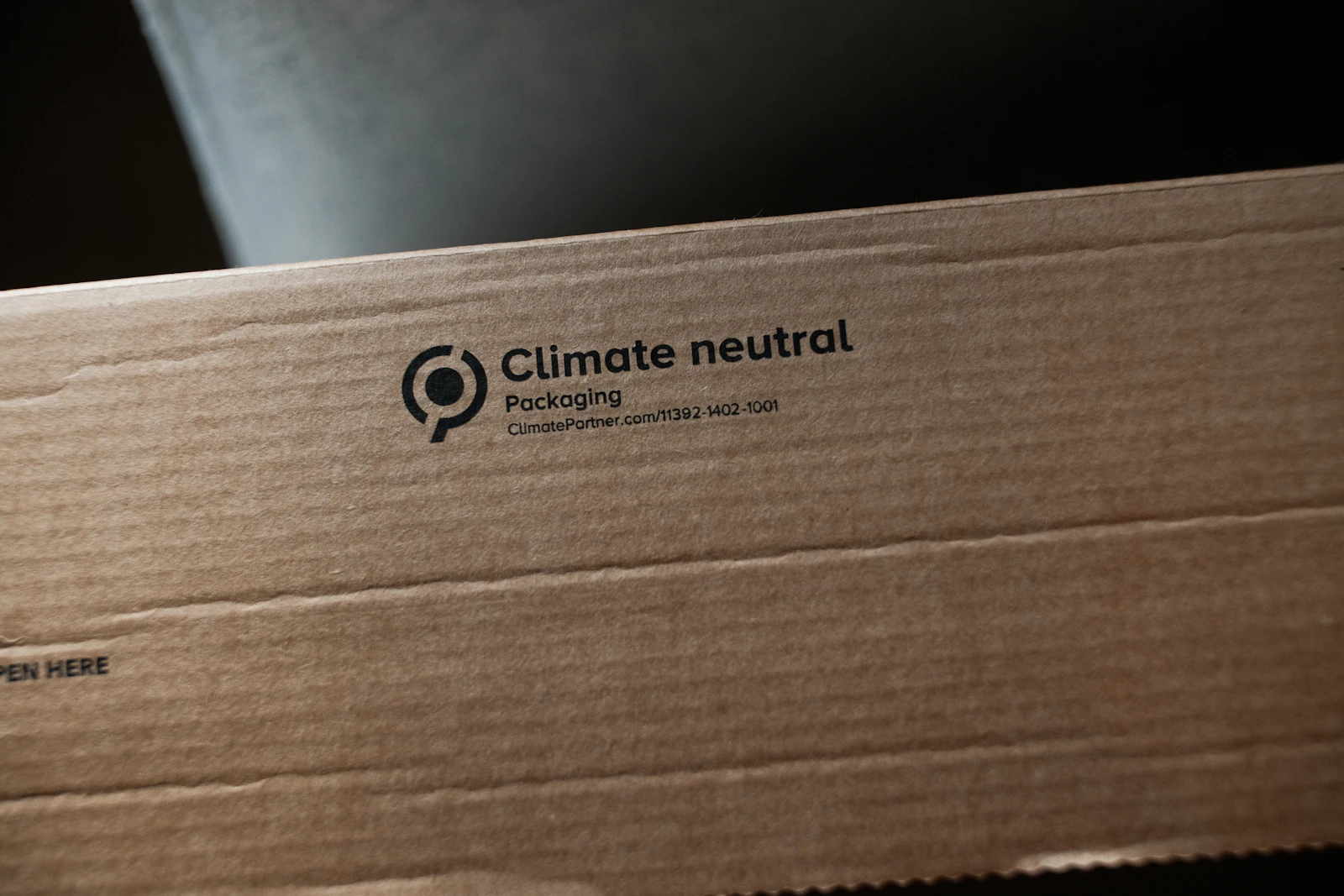 A sustainability certification symbol printed on a kraft cardboard box, representing packaging labels