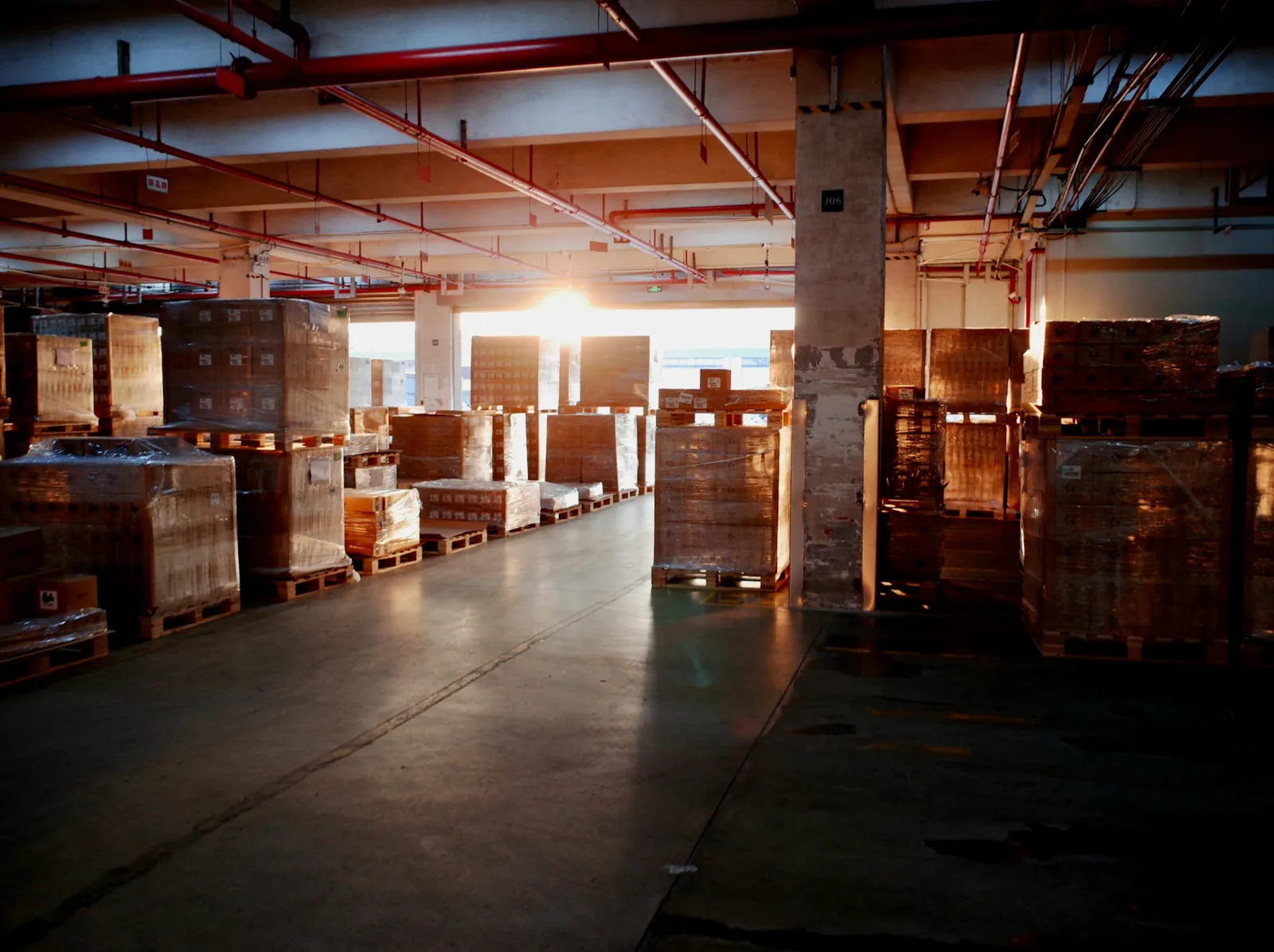 Stacked pallets wrapped in plastic stretch film in a distribution warehouse