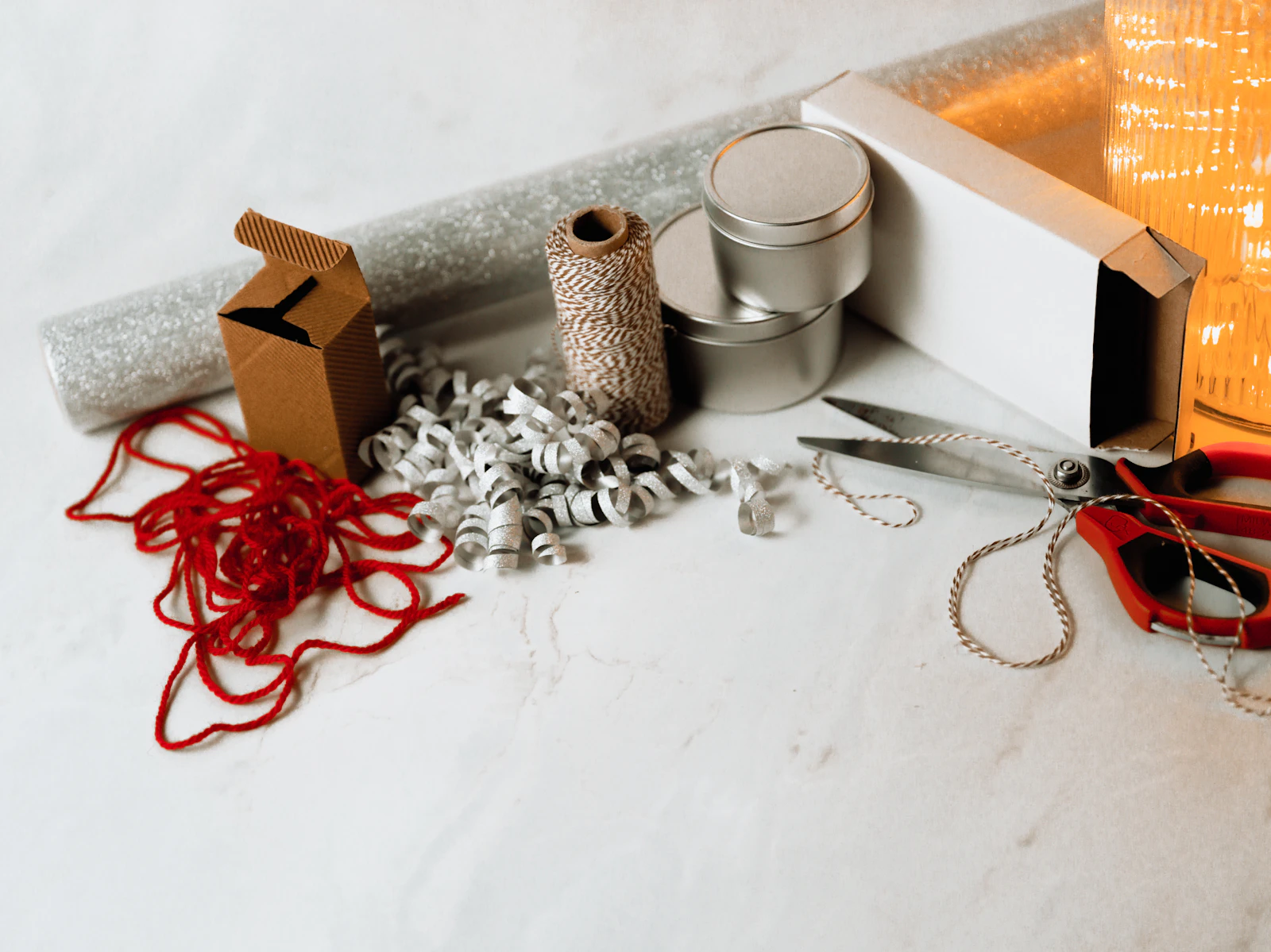 A flat lay of assorted packaging materials including a box, tins, paper and twine, representing packaging types
