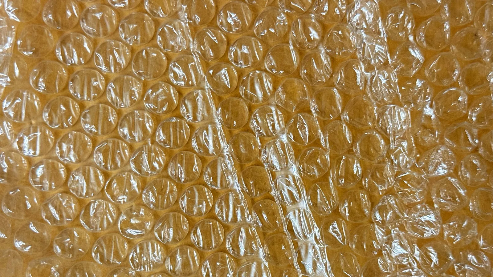 Close-up of clear bubble wrap over a brown surface